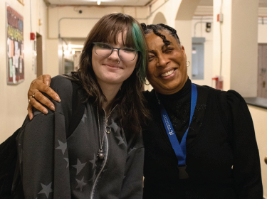 Teacher and Student pose with arms wrapped around the other
